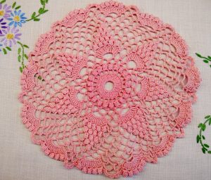 Pink crochet doiley on a linen cloth