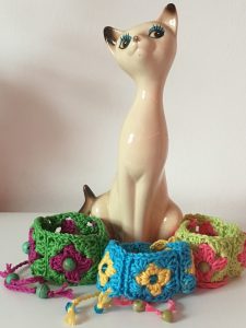 Cat ornament with three colourways of granny squares wristbands
