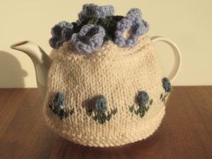Cream tea cosy with little blue flowers