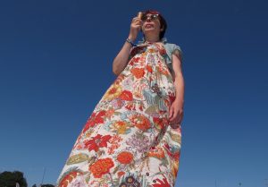 lady in floral maxi dress eating ice cream against blue sky