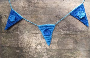 blue floral crochet bunting against board