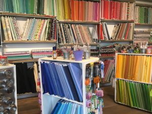 Colourful fabric on shelves at The Village Haberdashery