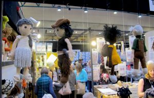 Toft stand at Knitting & Stitching Show with dolls hanging from the top
