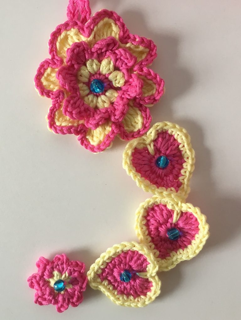 Hearts and flowers crochet wall hanging in pink and yellow