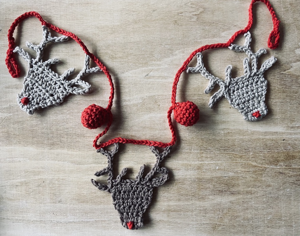 crocheted garland featuring reindeer and red baubles